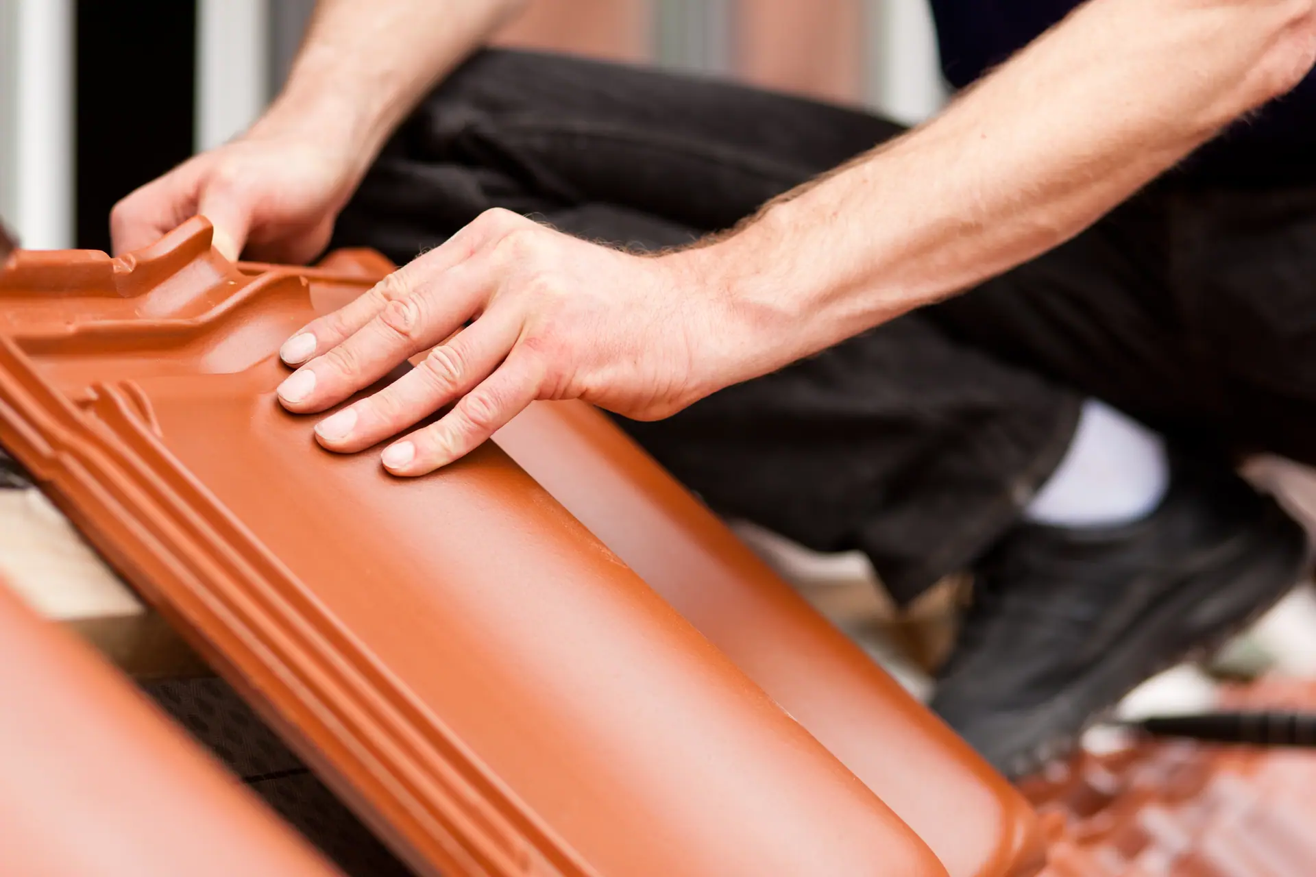 Roofer carefully placing a roof tile during maintenance work in Bournemouth for Apex Roofing Services