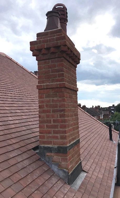 Traditional chimney on a tiled UK roof maintained by Apex Roofing Services Bournemouth