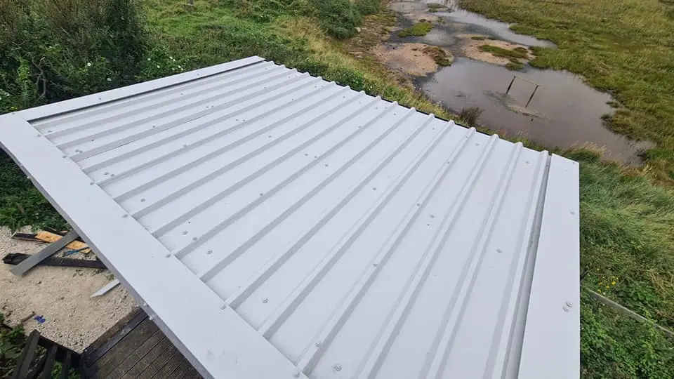 Metal roof sheets being fitted to an outbuilding in East Dorset by Apex Roofing Services